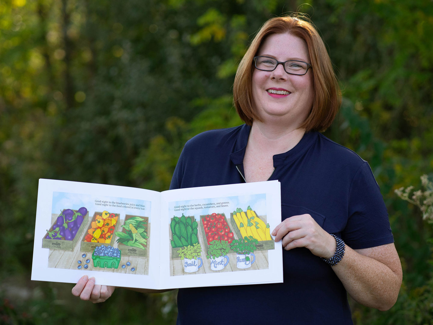 Kathleen Vallejos with her book smiling